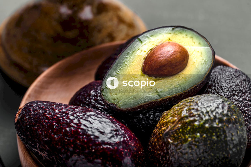 Sliced avocado fruit on brown wooden chopping board
