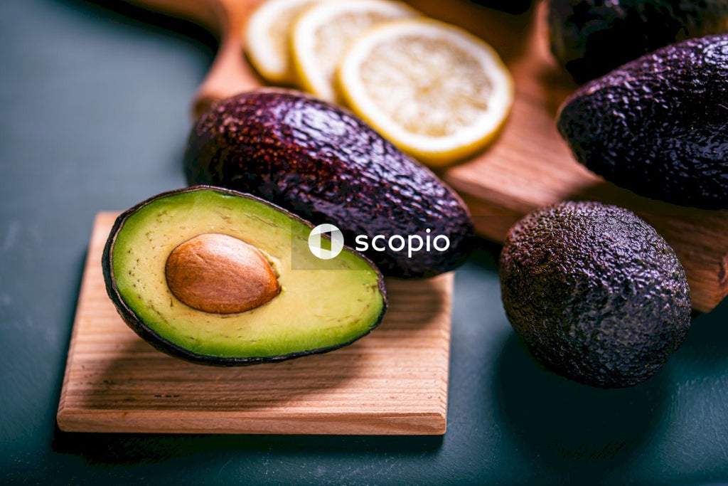 Sliced avocado fruit on brown wooden chopping board