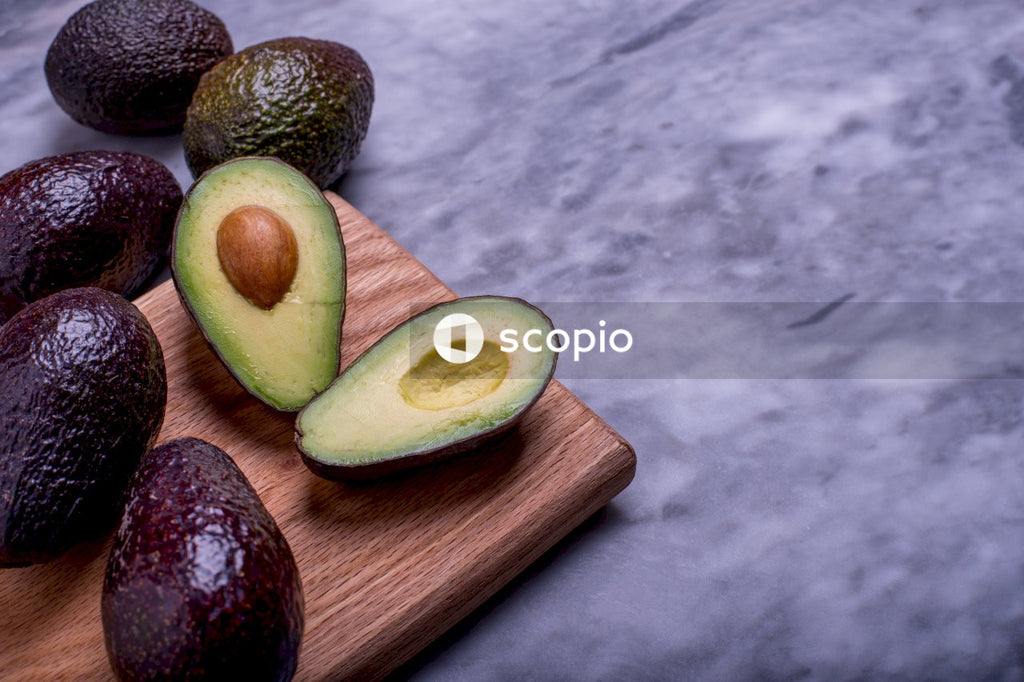 Sliced avocado fruit on brown wooden chopping board