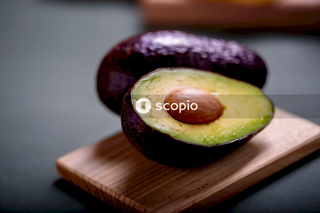 Sliced avocado fruit on brown wooden chopping board