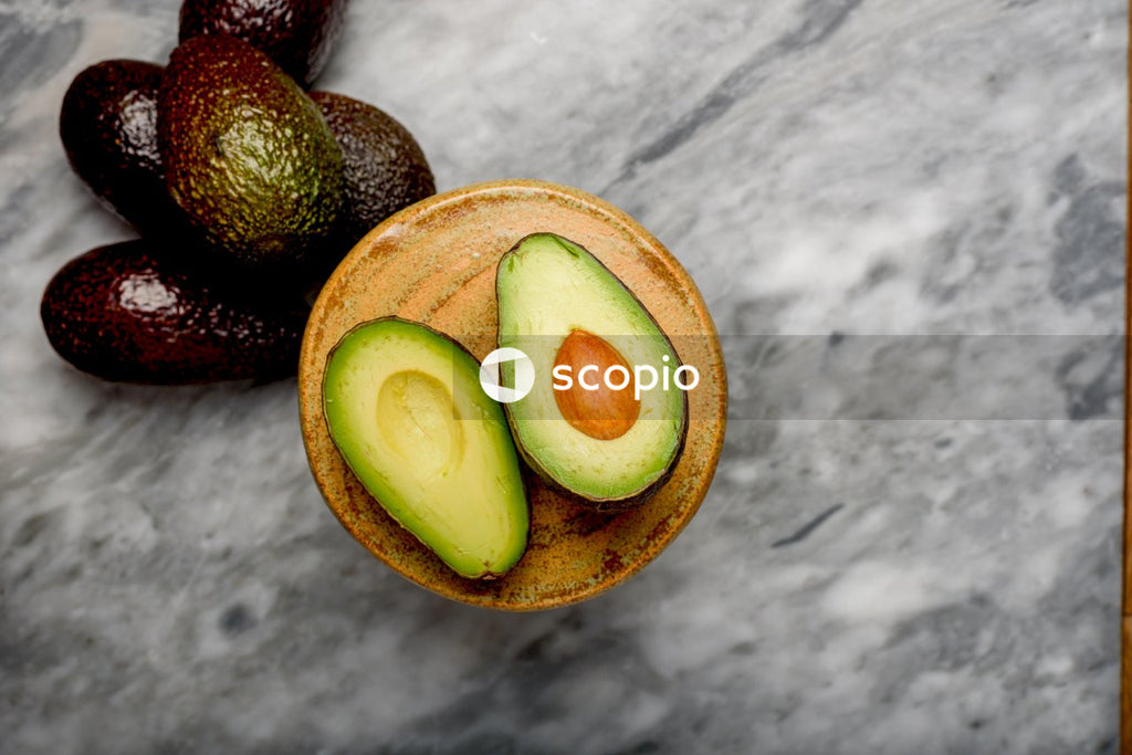 Sliced avocado fruit on gray textile