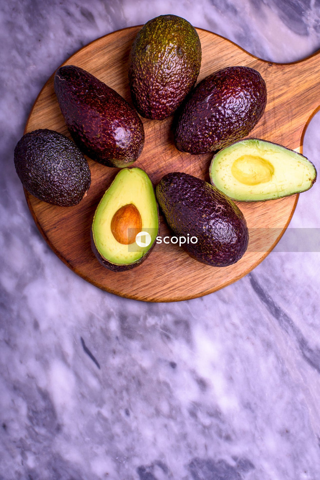 Sliced avocado on brown wooden plate