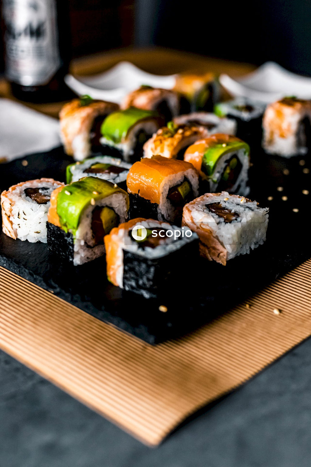 Sliced meat with green vegetable on black rectangular plate