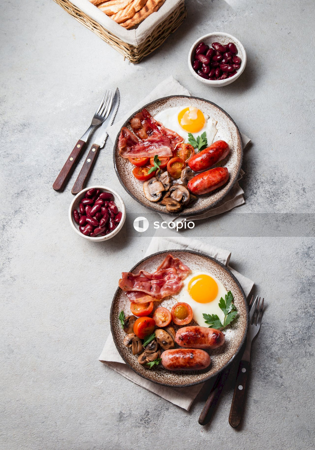 Sliced tomato and green vegetable on white ceramic plate beside stainless steel fork and bread knife