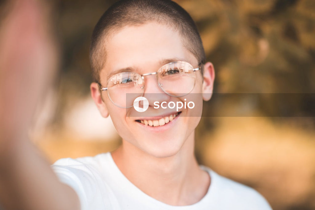 Smiling man in white crew neck shirt wearing eyeglasses