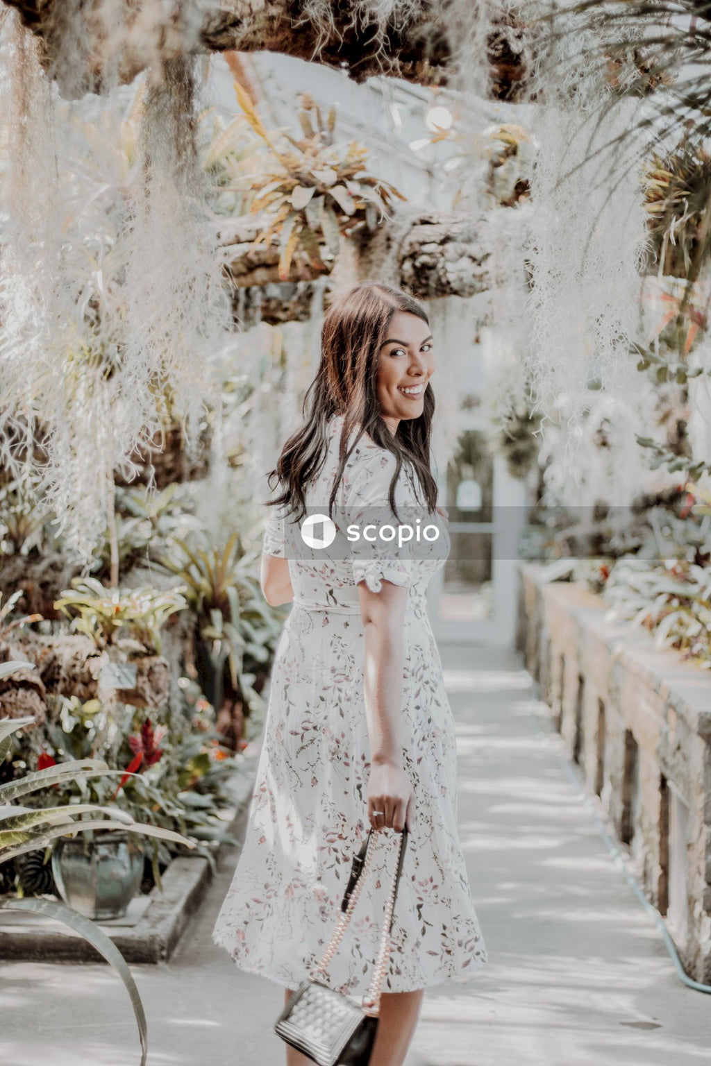 Smiling woman in light dress standing on pathway