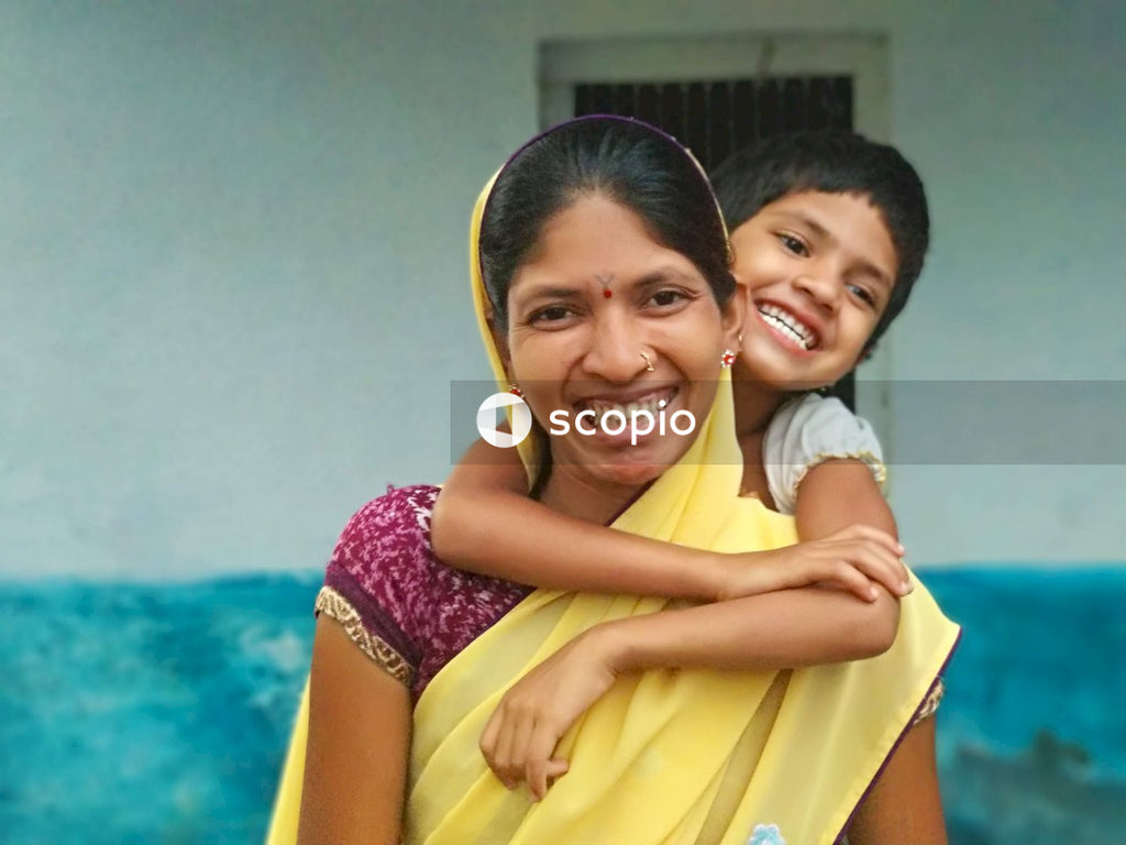 Smiling woman in purple and white floral dress hugging smiling man in yellow shirt