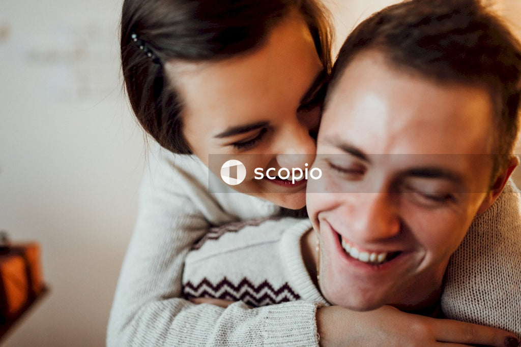 Smiling woman in white sweater hugging smiling woman in white sweater