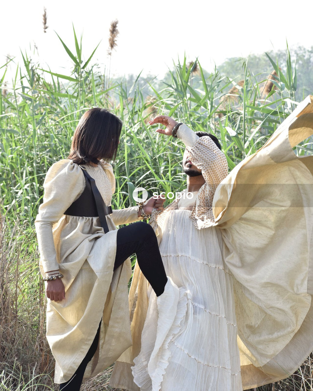 Two men wearing dresses danding on green grass field during daytime