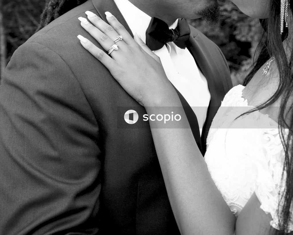 Grayscale of bride and groom kissing in close-up