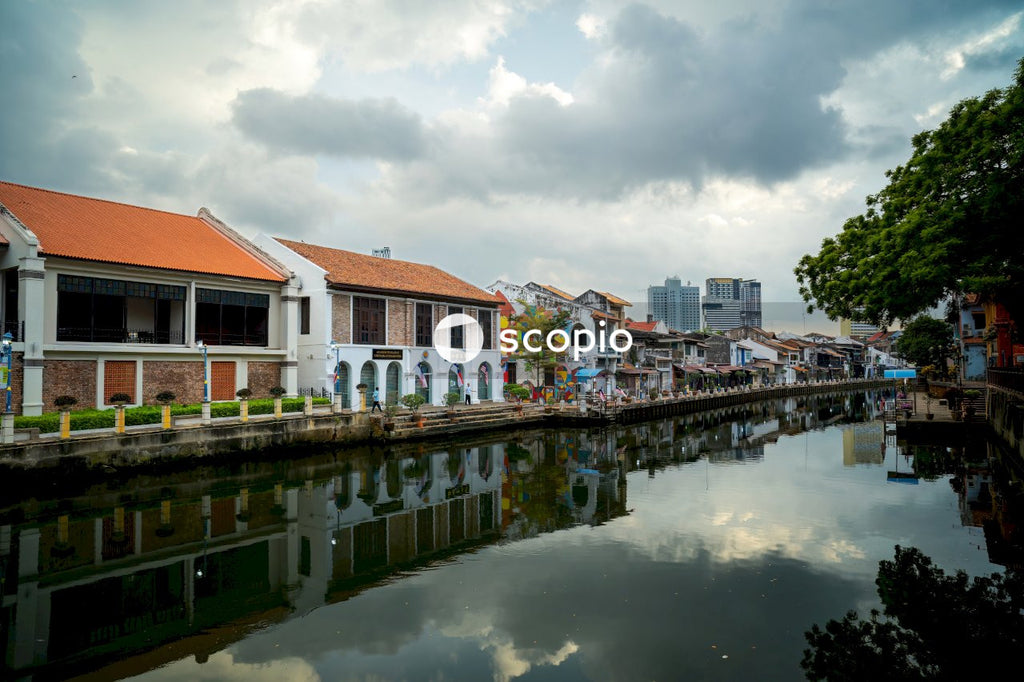White and brown concrete houses near body of water under white clouds