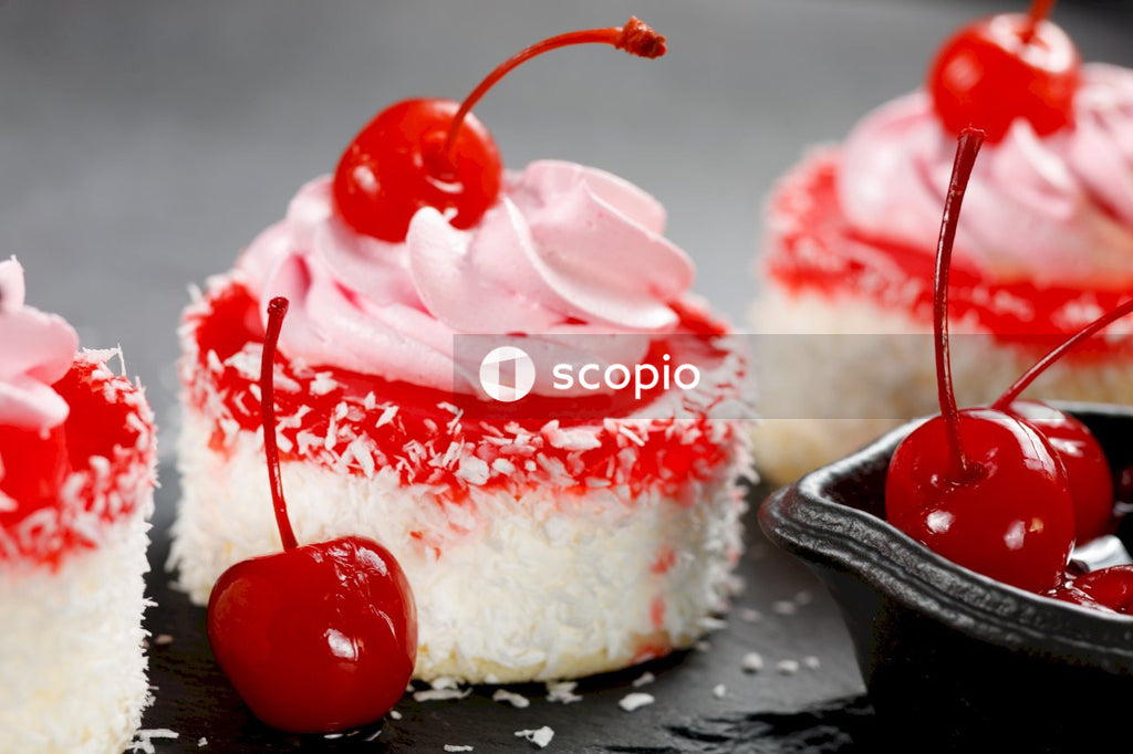White and red cake with cherry on top
