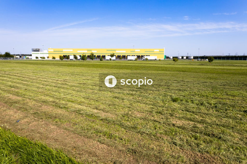 White and yellow building on green grass field under blue sky