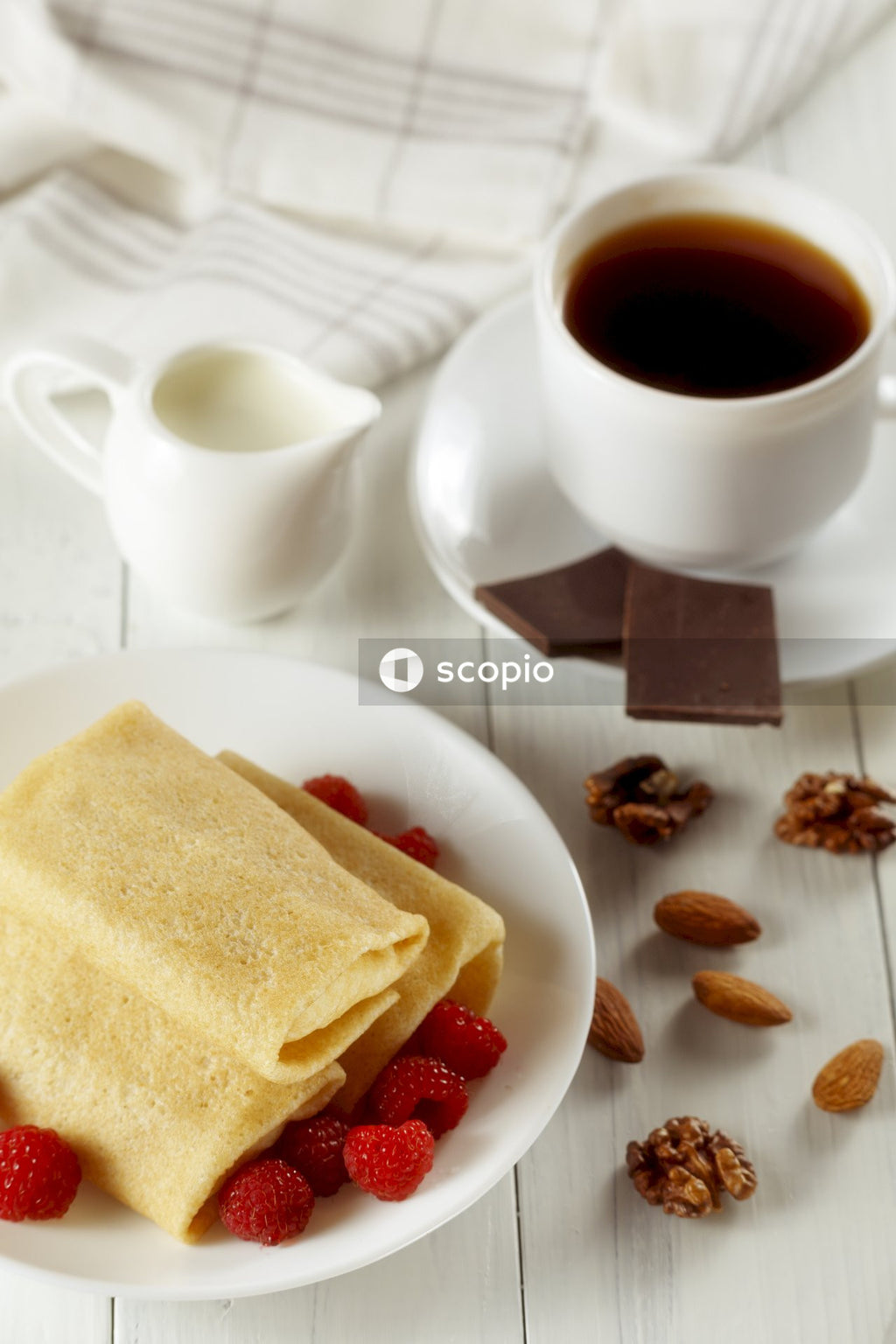 White ceramic mug with coffee beside brown bread on white ceramic plate