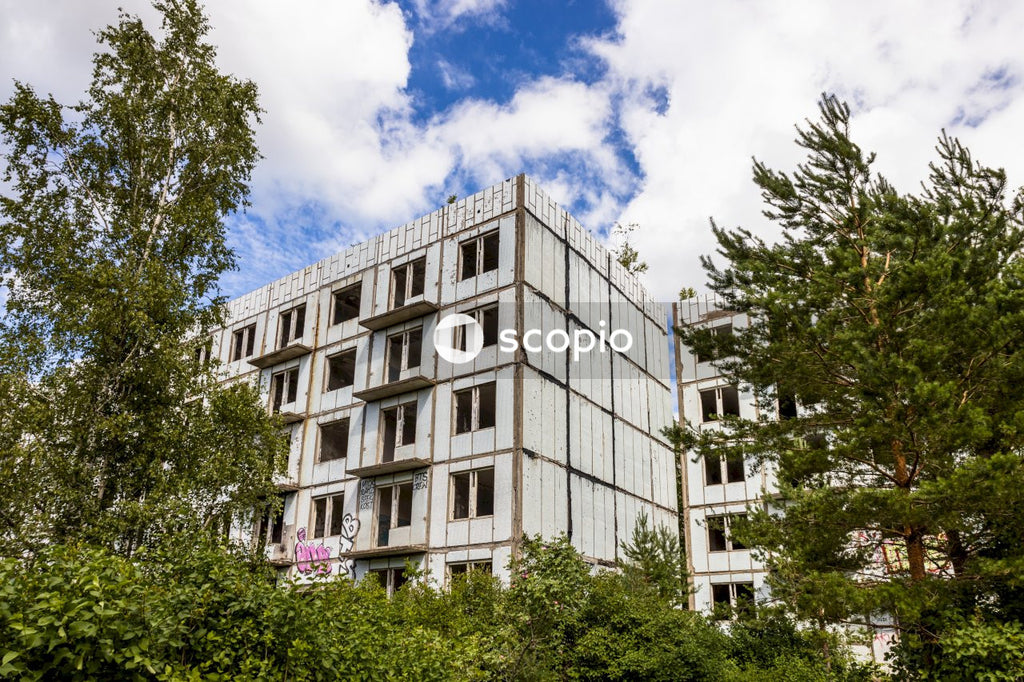 White concrete building near green trees under blue sky