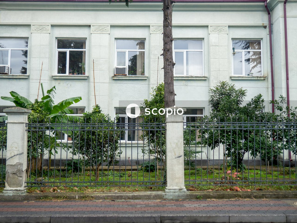 White concrete building with black metal fence