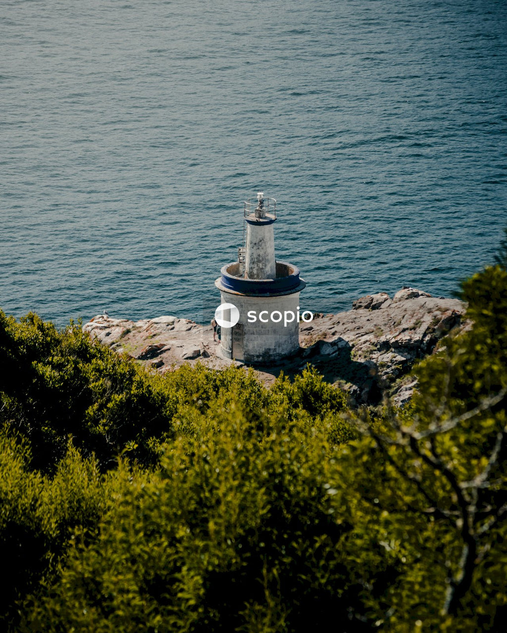 White concrete lighthouse on cliff by the sea