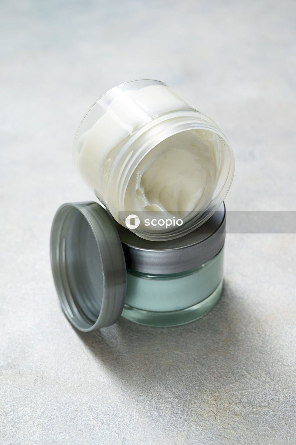 White cream in clear glass jar