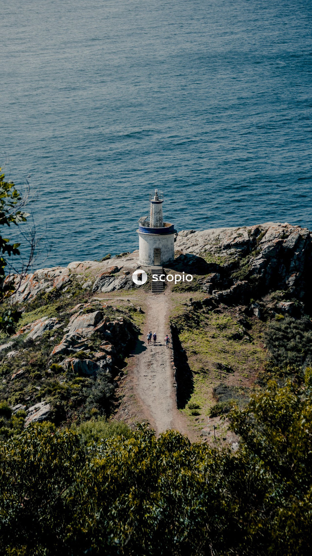 White lighthouse on brown rocky shore