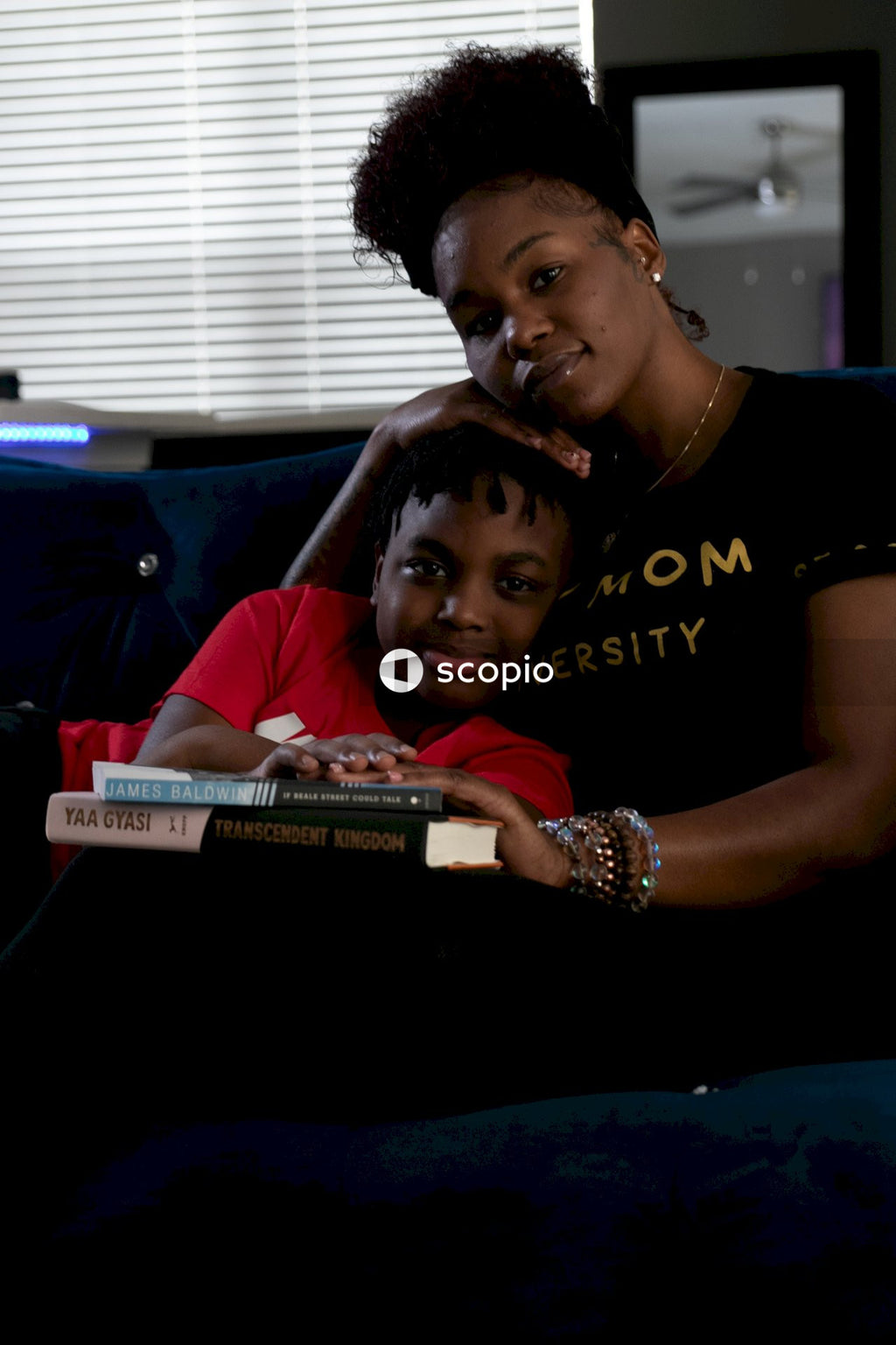 Woman and kid putting their hands on two books