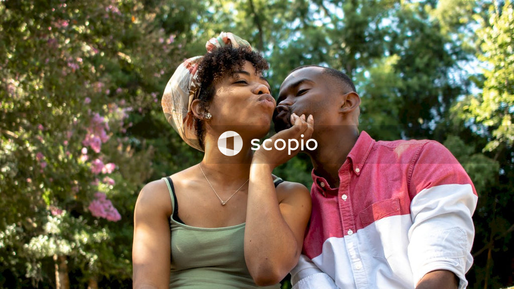Woman holding man's face and kissing outdoor