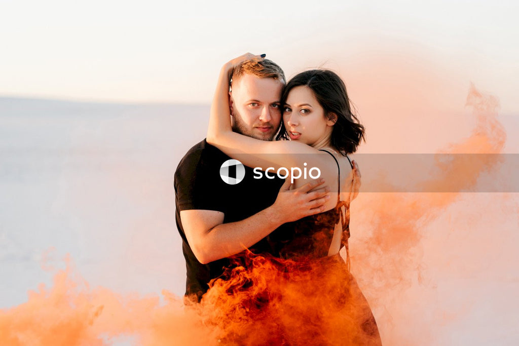 Woman in black dress hugging woman in orange dress