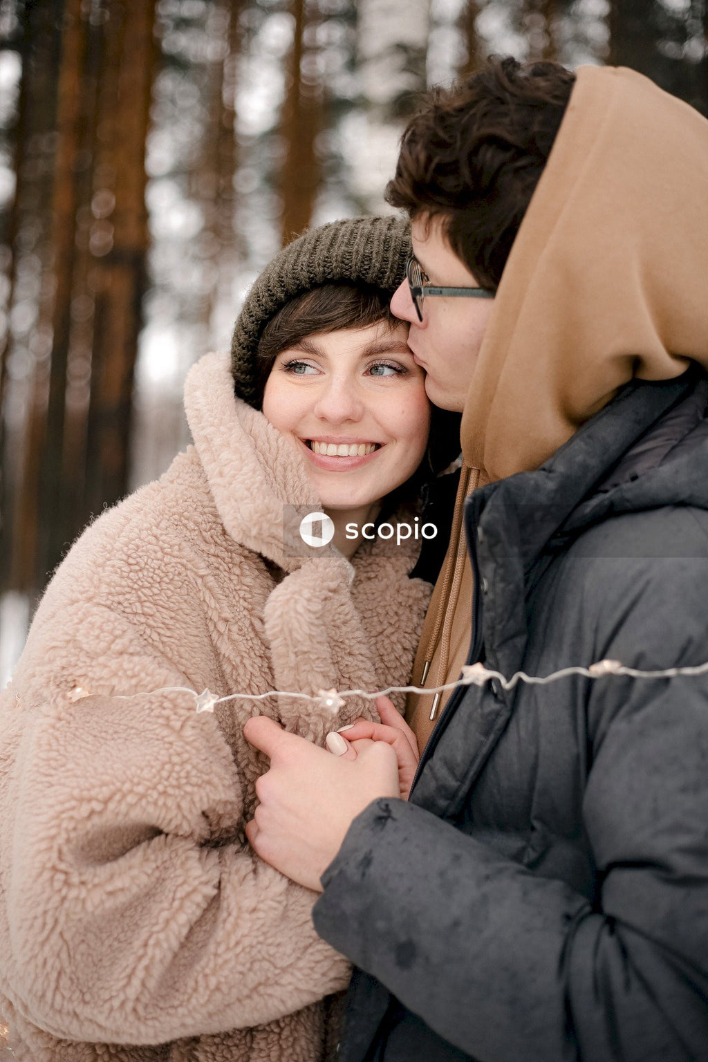 Woman in black jacket hugging woman in brown coat