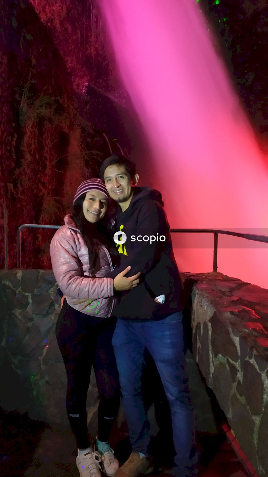 Couple standing beside waterfall in Baños de Agua Santa, Ecuador