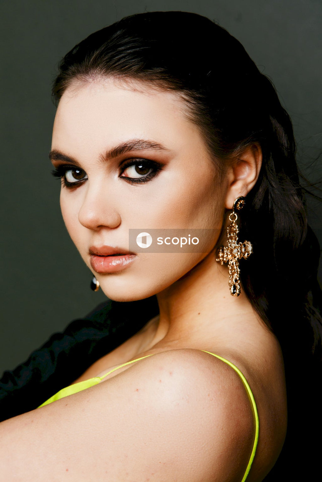 Woman in black jacket wearing gold necklace
