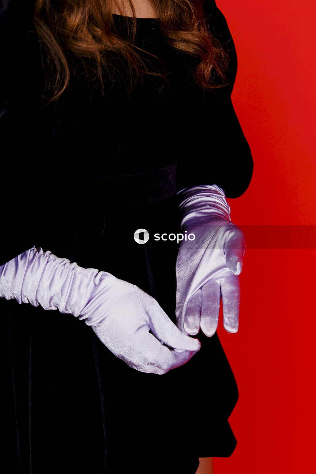 Woman in black leather jacket holding hands with red background