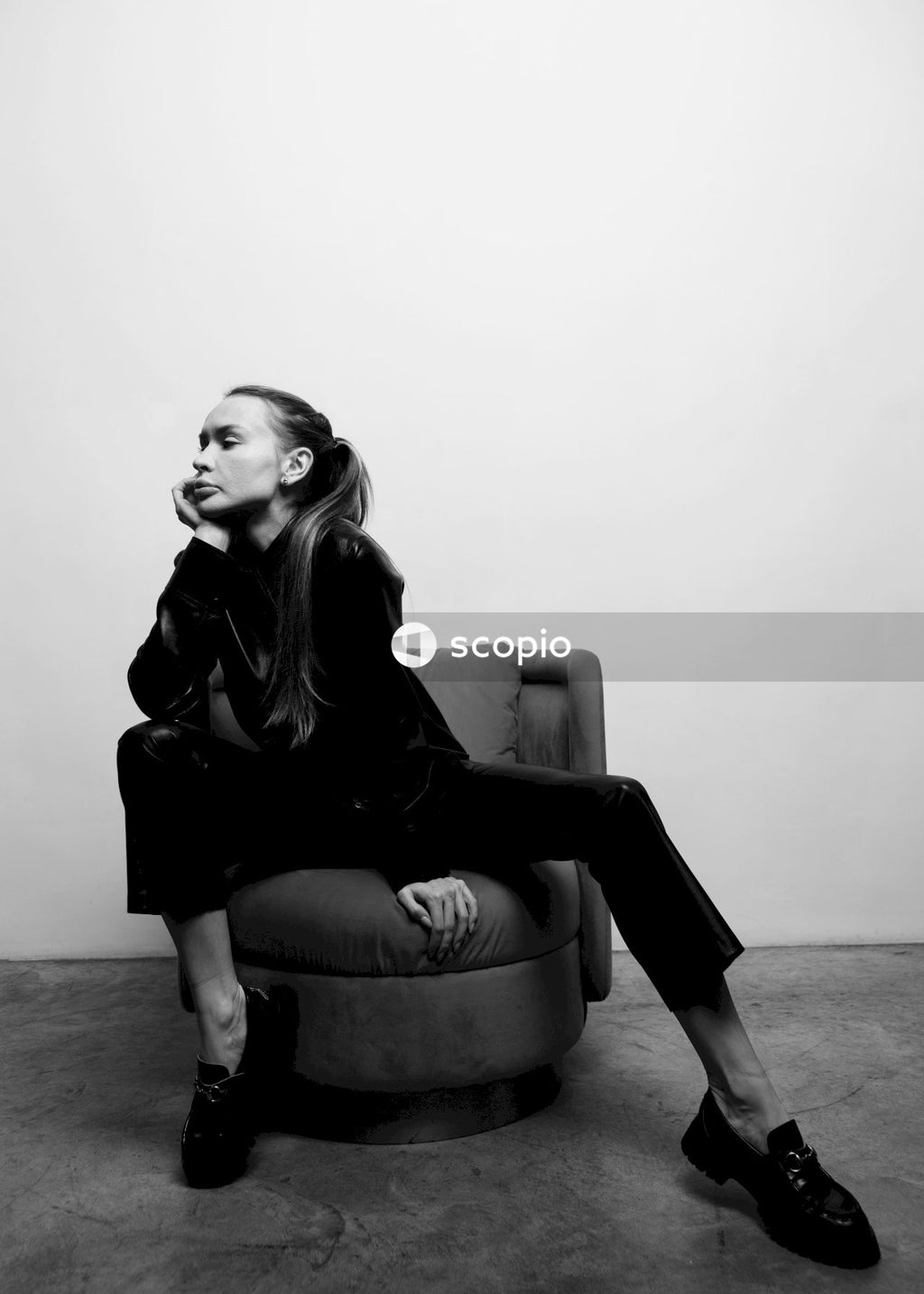 Woman in black leather jacket sitting on sofa chair