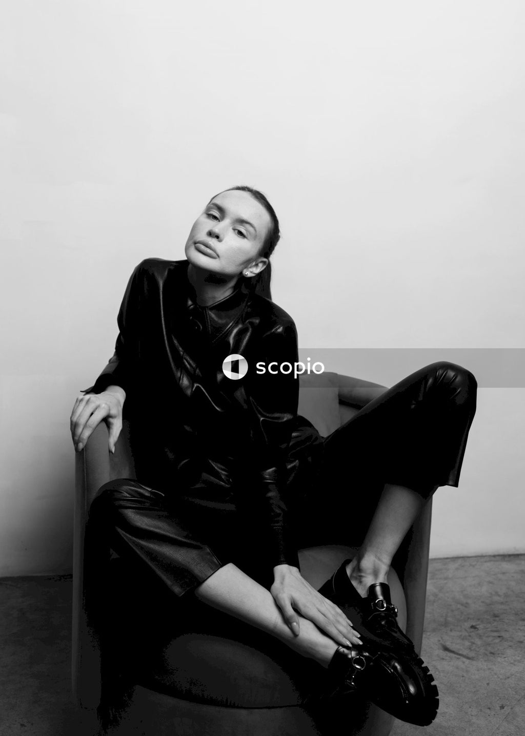 Woman in black leather jacket sitting on the floor