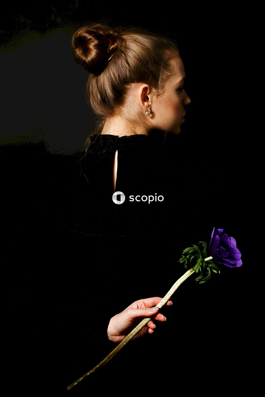 Woman in black long sleeve shirt holding purple flower