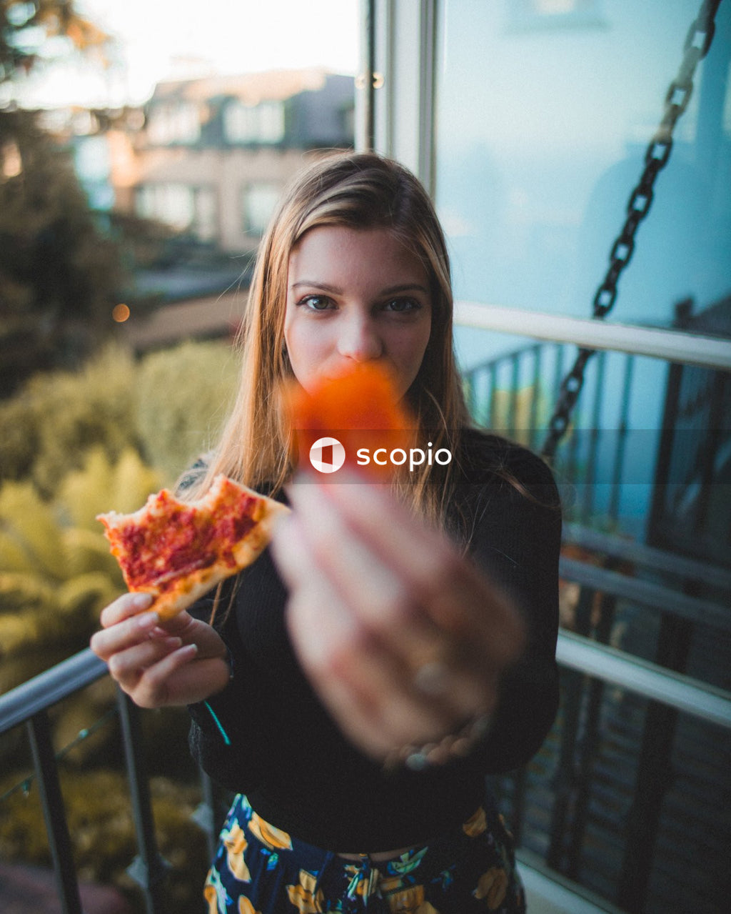Woman in black long sleeve shirt holding sliced of pizza