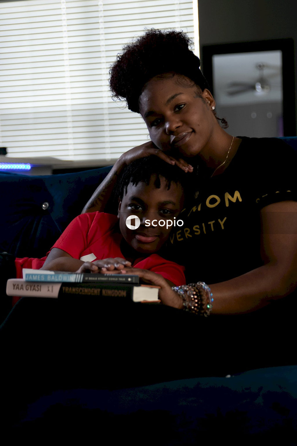 Woman and kid putting their hands on two books