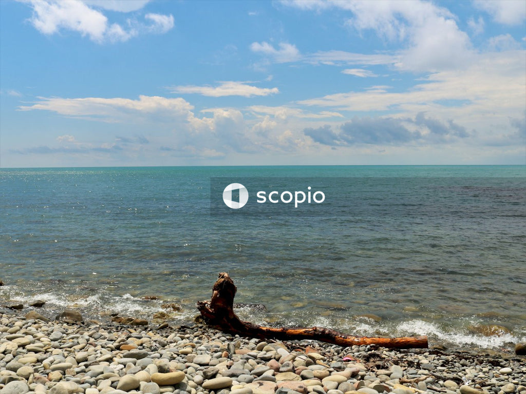 Woman in black shirt sitting on rock near sea