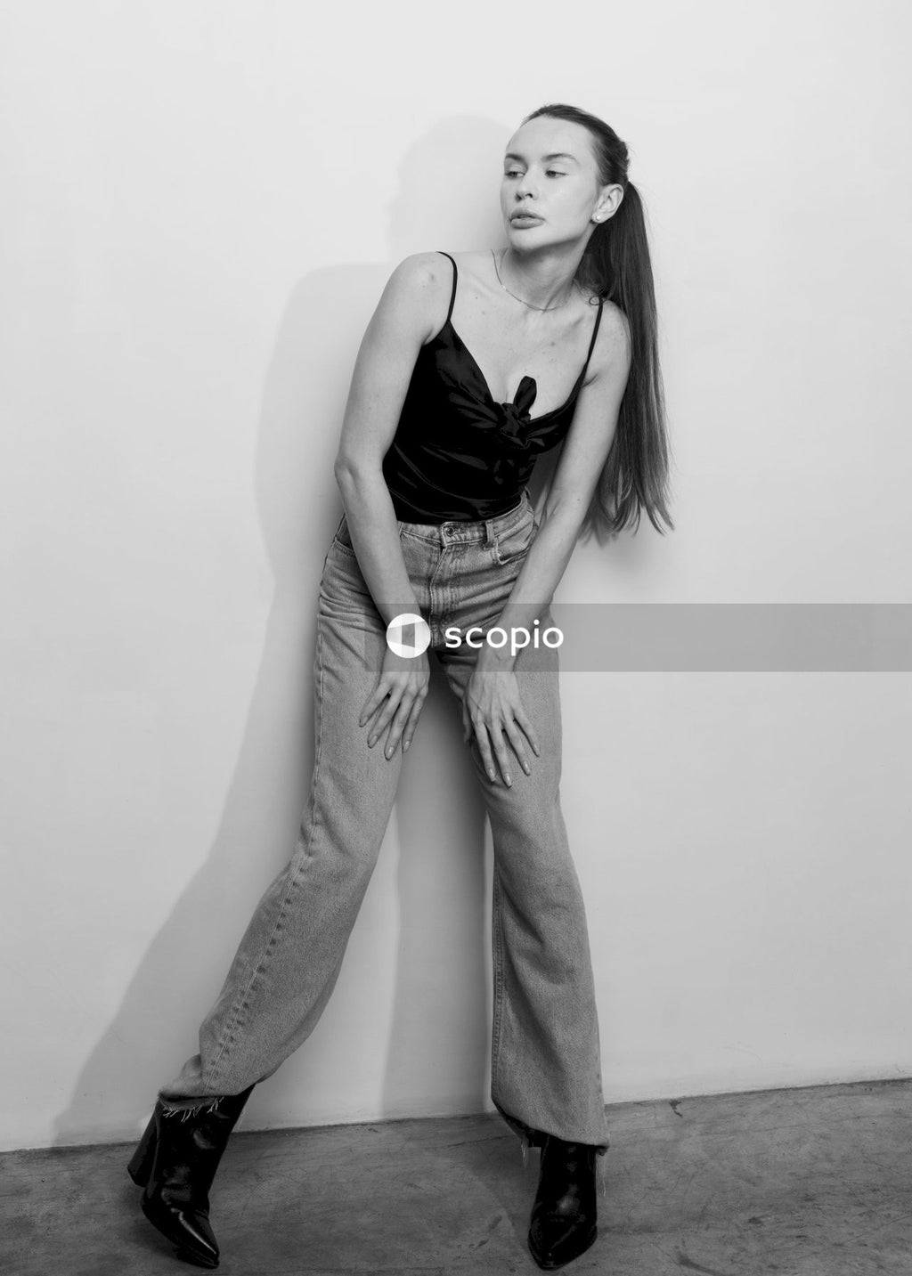 Woman in black tank top and gray denim jeans