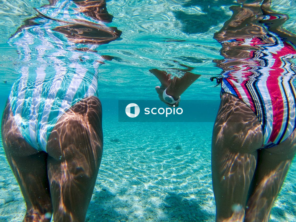 Under water shot Two women in bathing suits holding hands in the swimming pool