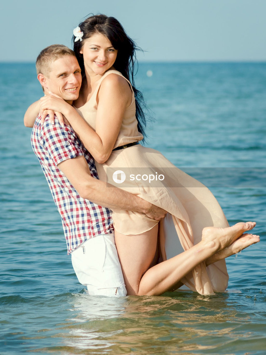 Woman in blue and white plaid dress shirt hugging man in white shirt on body of near on near near