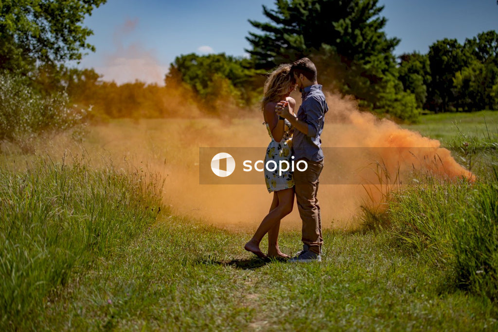 Woman and man hugging on green grass field