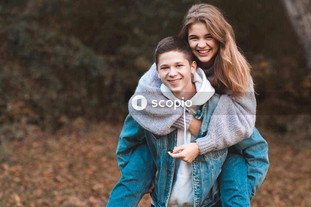 Romantic teenage couple wear casual clothes in autumn park outdoor having fun