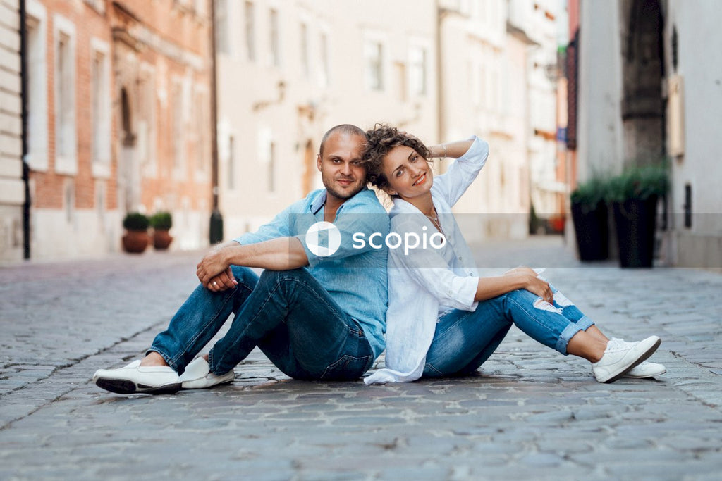 Woman and man sitting on street floor