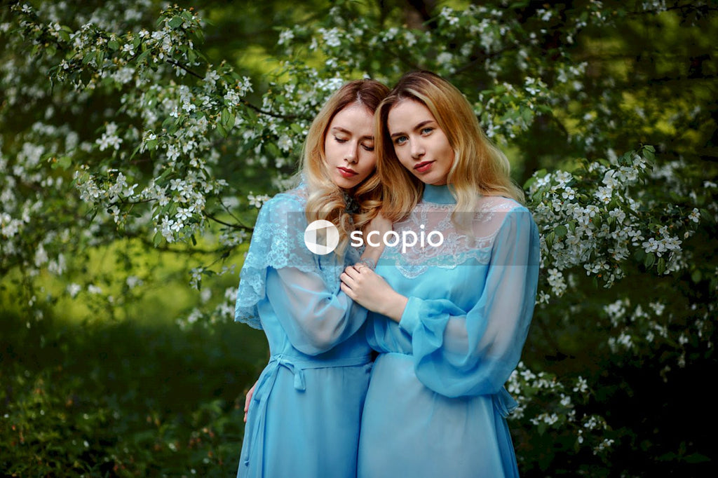 Woman in blue dress hugging woman in white floral dress