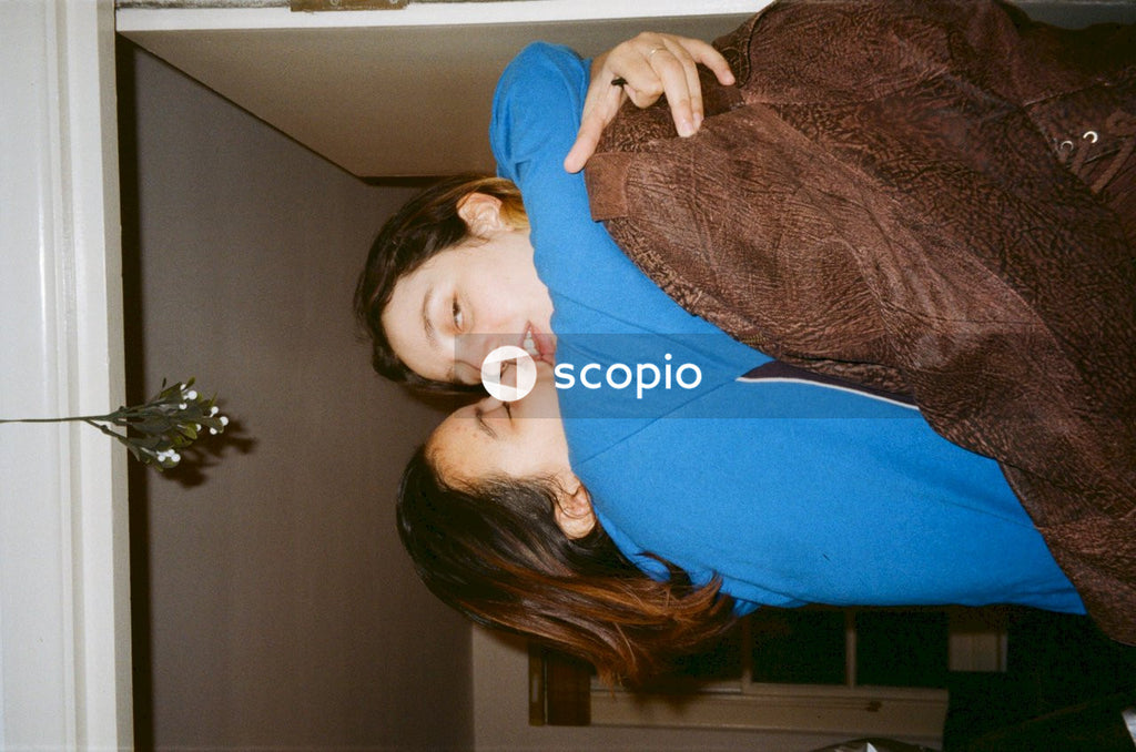 Two women kissing beside door