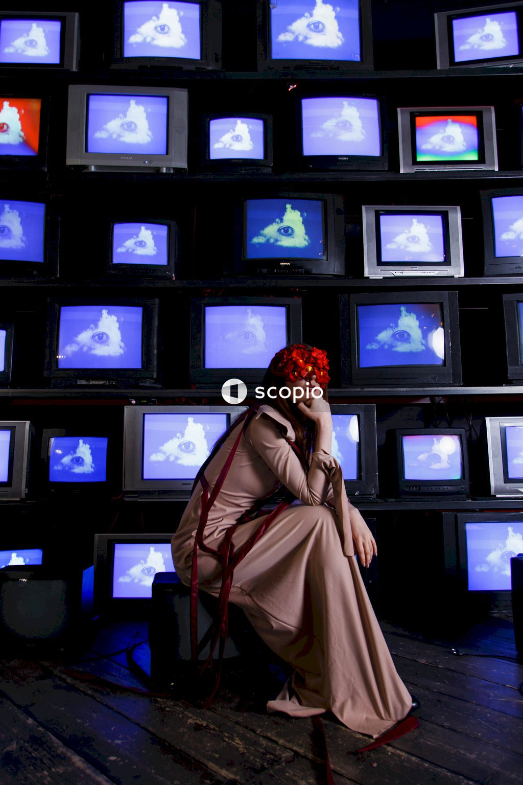 Woman in brown coat standing in front of black crt tv