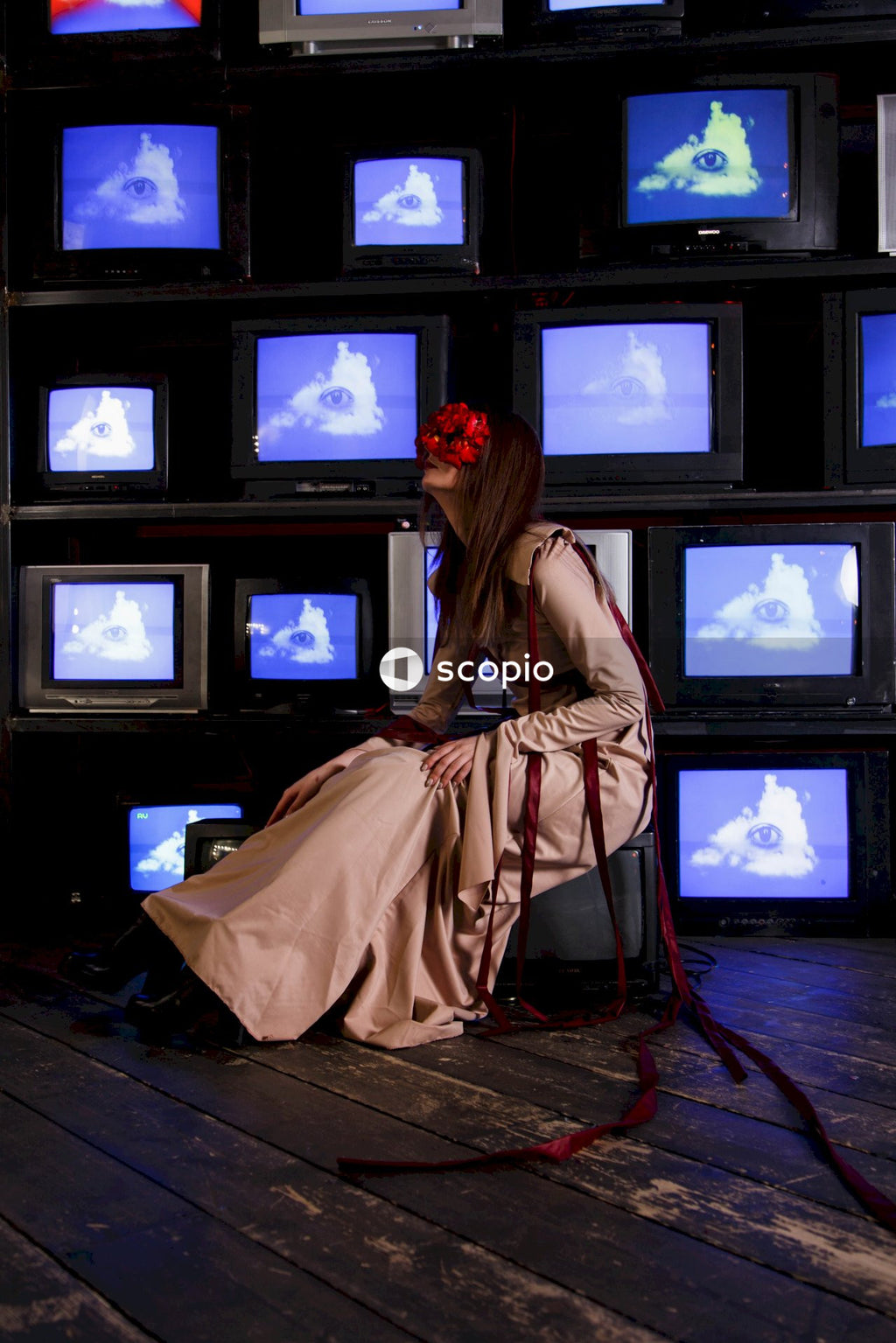 Woman in brown dress standing in front of black crt tv