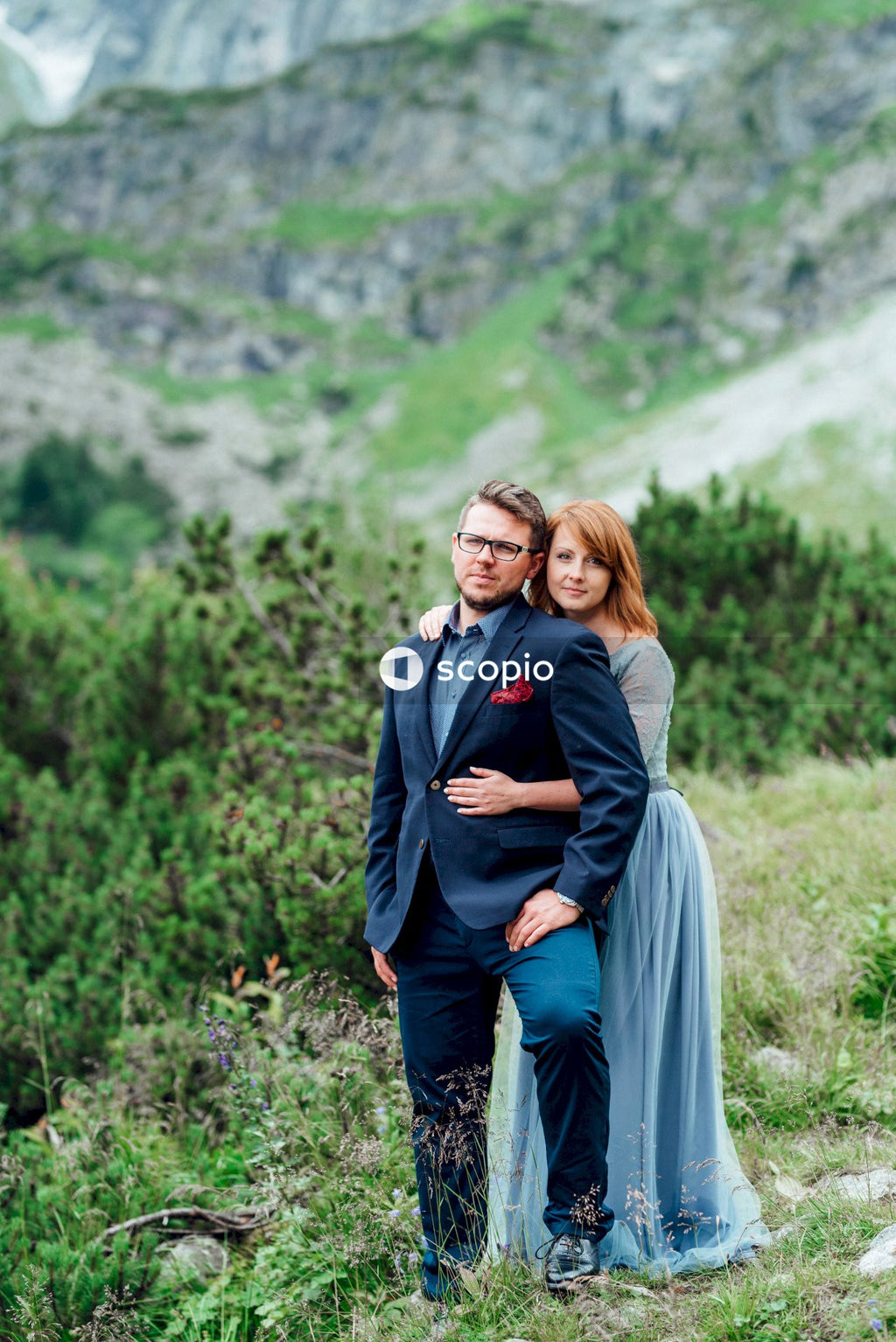 Woman in gray long sleeve dress hugging woman in black long sleeve shirt