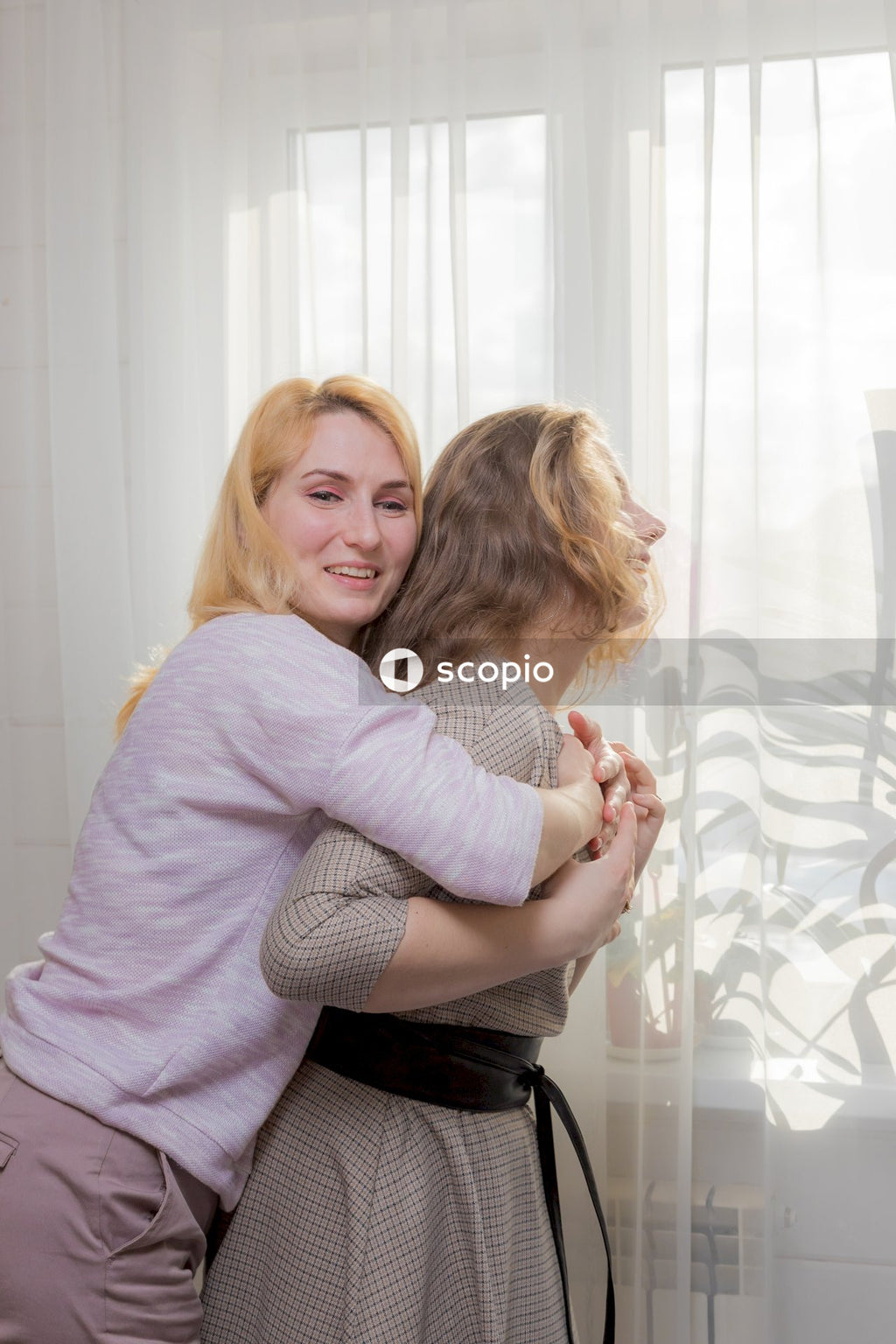 Woman in gray sweater hugging woman in gray sweater