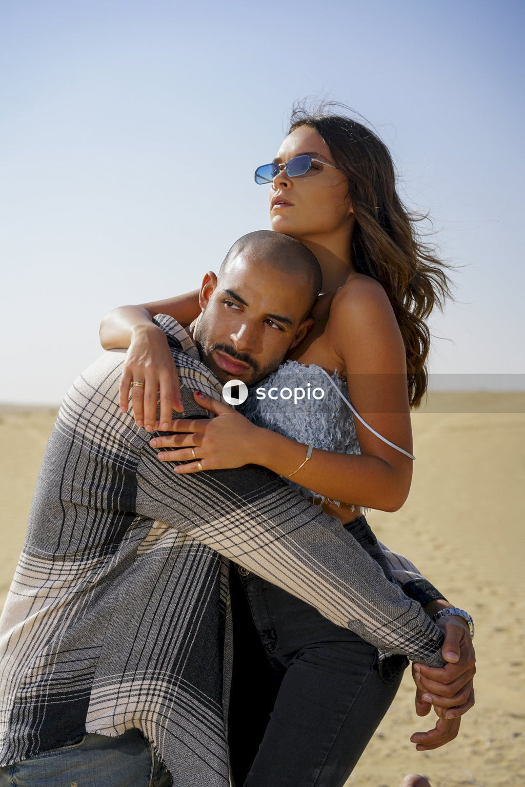 Woman in gray tank top hugging man in gray shirt