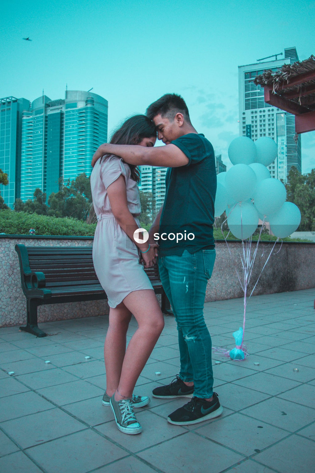 Woman in green dress hugging man in green dress shirt